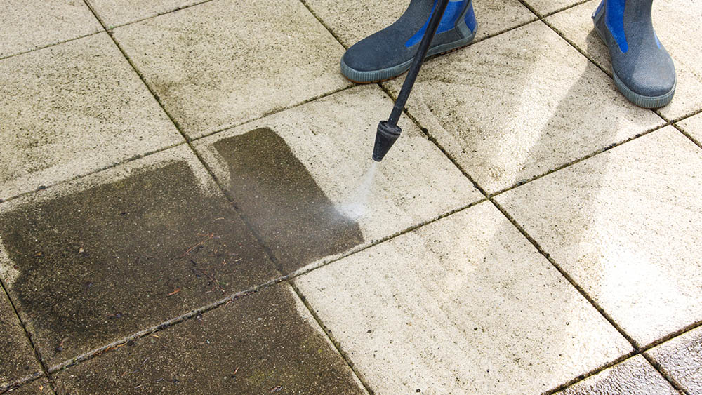 Dirty tiles that are in the process of being pressure washed