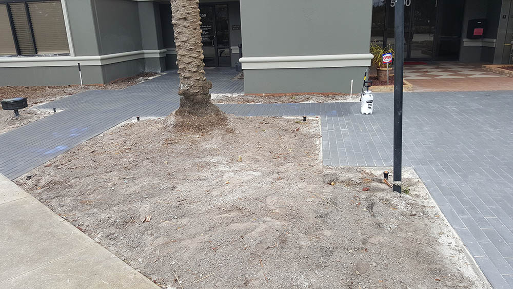 A concrete walkway that is in the middle of being professionally cleaned