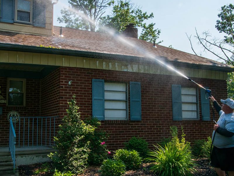 Two Perfect Pear employees soft washing the roof of a house